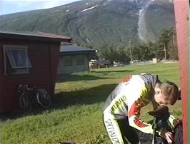Julian packs his bike outside his cabin at Skjåk youth hostel
